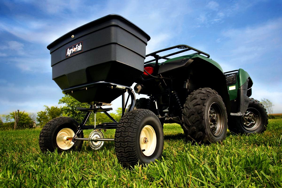 Broadcast spreader equipment on a green lawn